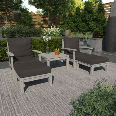 Deep seating lounge set with black cushions and gray frames in outdoor patio area. 