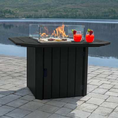 Black Oasis Fire Table with lit flame and lake in background. 