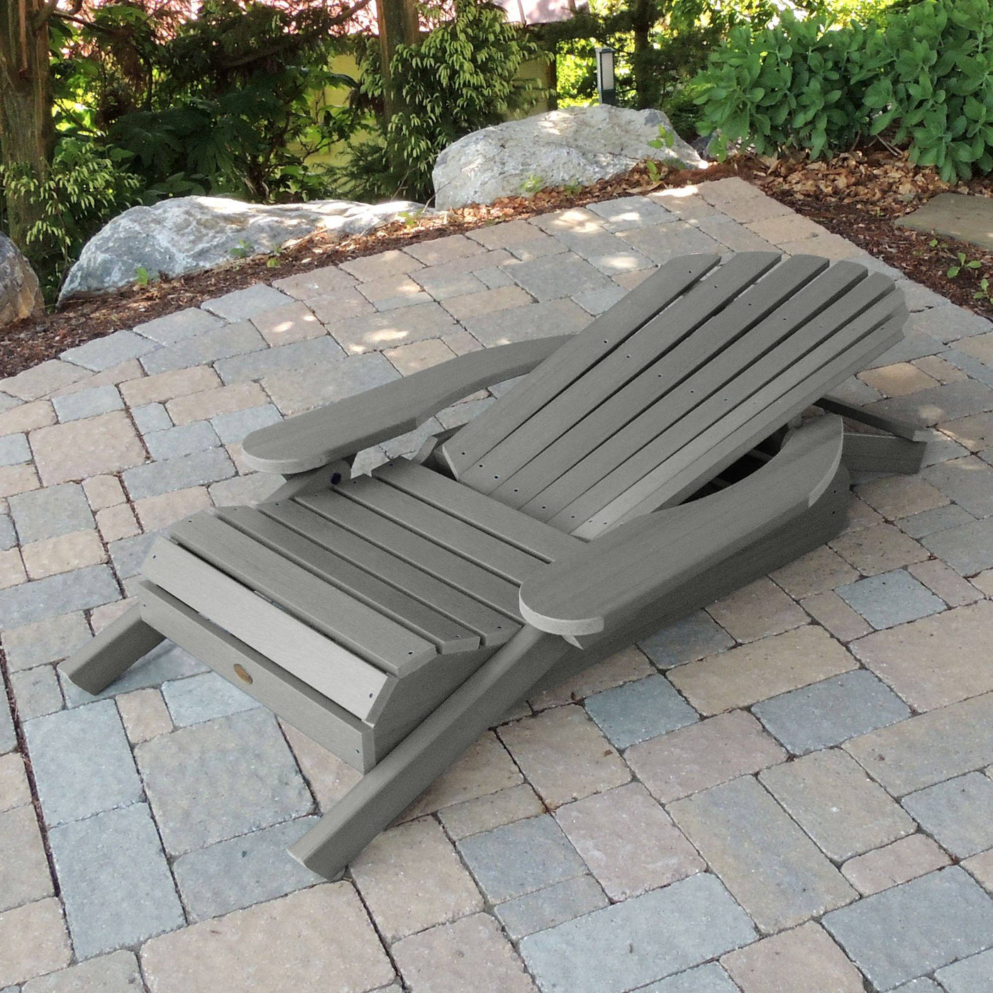 Folded Hamilton Adirondack chair in Coastal Teak gray on stone