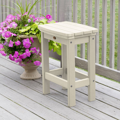 Whitewash Lehigh counter height stool on deck with flowers 