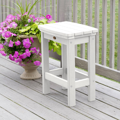 White Lehigh counter height stool on deck with flowers 