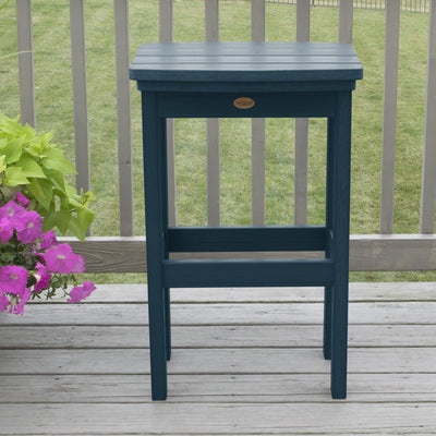 Light blue Lehigh bar height stool on deck with flowers in background