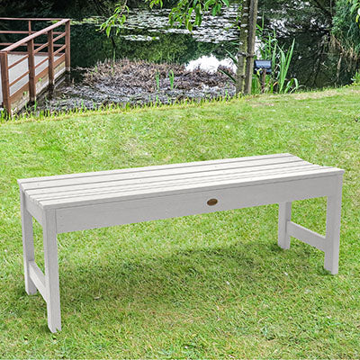 White 4ft Lehigh backless bench on grassy area. 