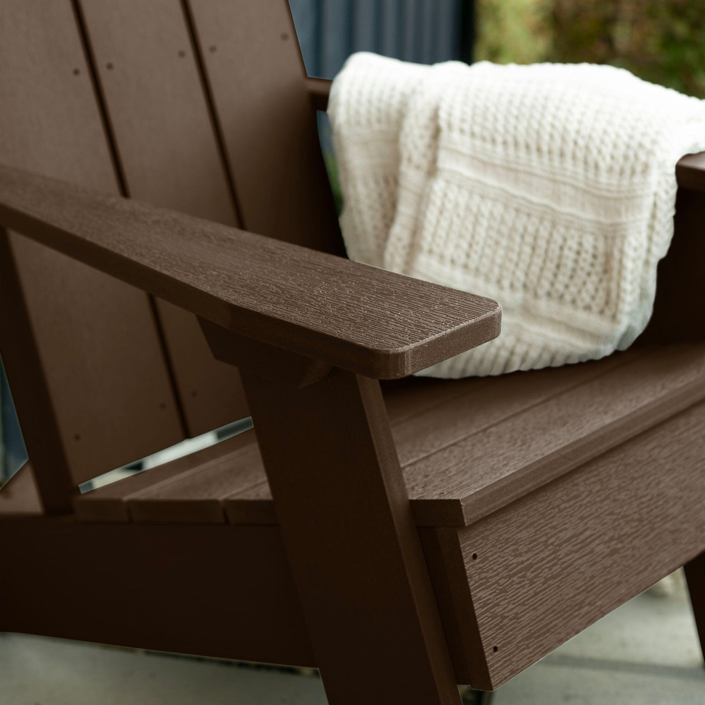 Close up of Brown Italica Modern Adirondack Chair with blanket