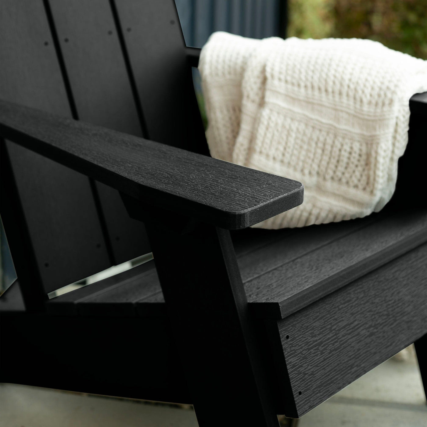 Close up of Black Italica Modern Adirondack Chair with blanket