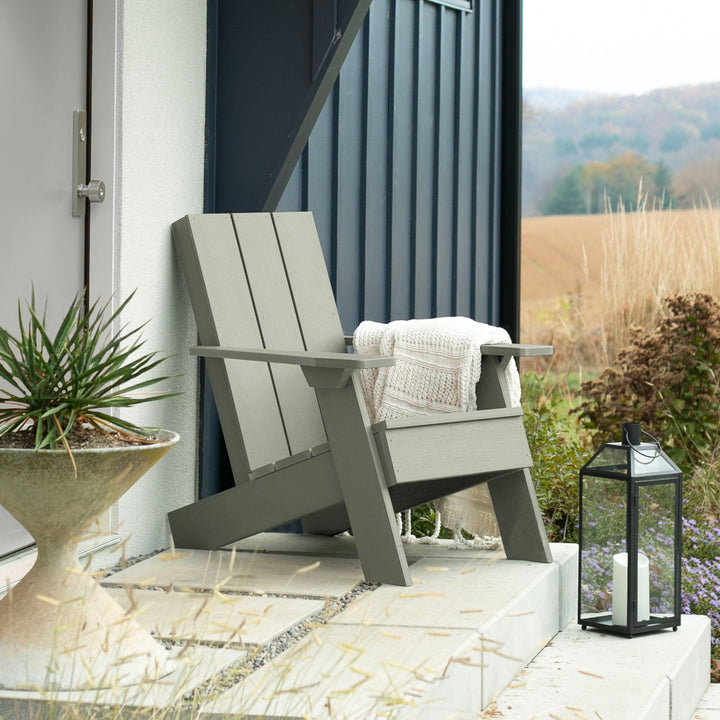 Light green Italica Modern Adirondack chair on porch with blanket and lantern