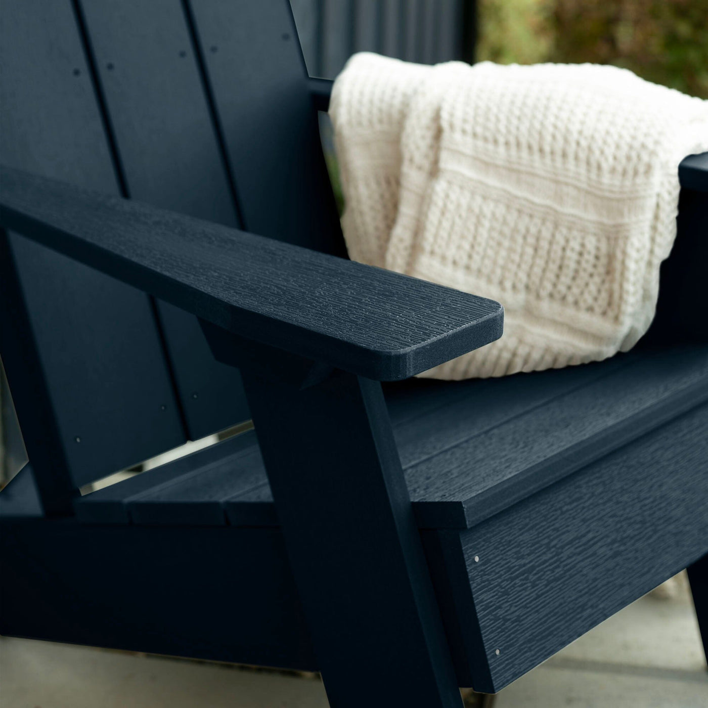 Close up of Dark blue Italica Modern Adirondack Chair with blanket