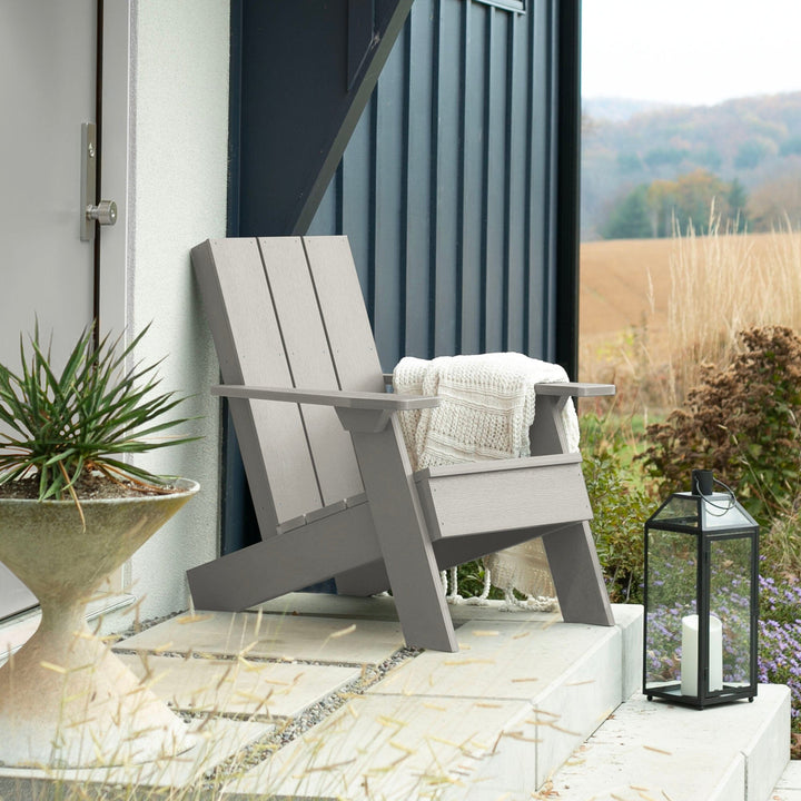 Light gray Italica Modern Adirondack chair on porch with blanket and lantern