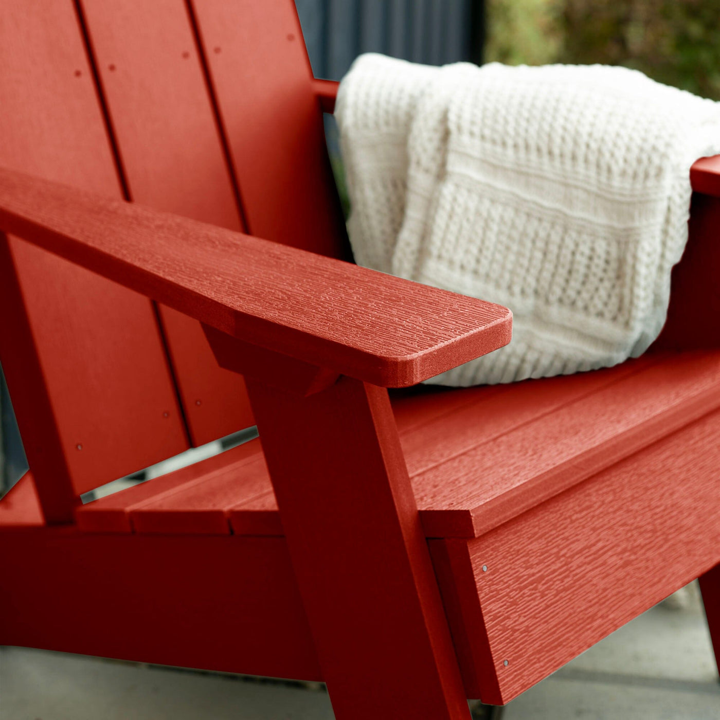 Close up of Red Italica Modern Adirondack Chair with blanket
