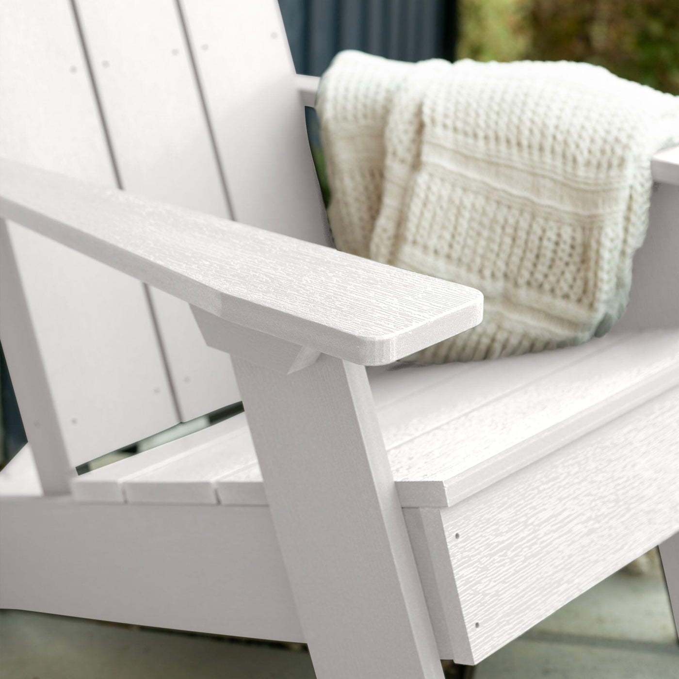 Close up of White Italica Modern Adirondack Chair with blanket