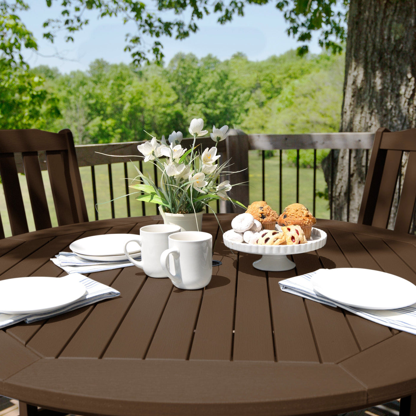 Table setting with flowers and pastries on a round brown table