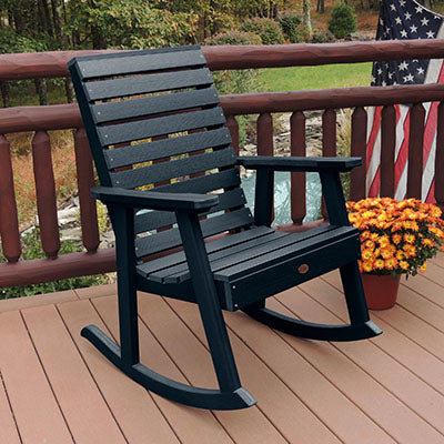 Dark Blue Weatherly Rocking chair on wooden deck. 