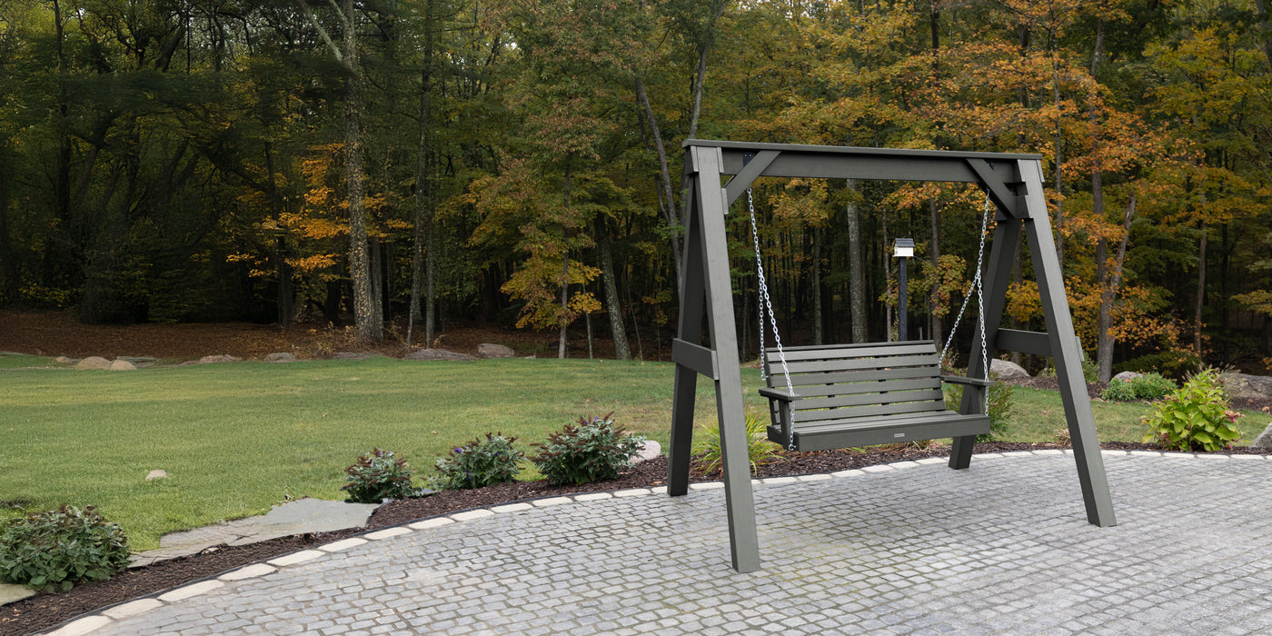 Swing set in a park with trees and grass in the background