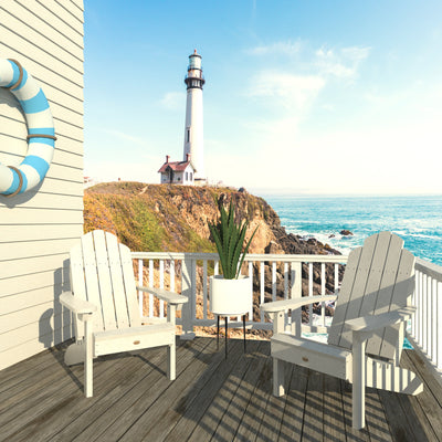 Two white Westport Adirondack chairs with lighthouse in the background.