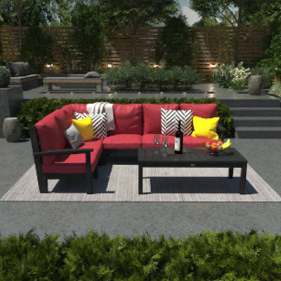 Deep Seating Sectional and conversation table with red cushions and black frames in a stone gathering area. 