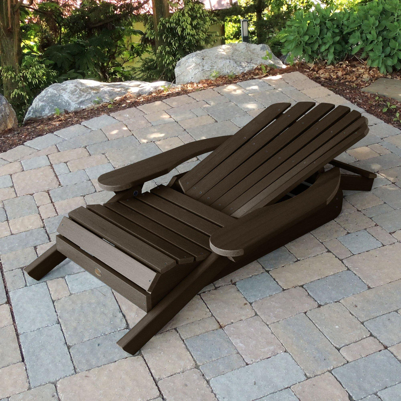 Folded Hamilton Adirondack chair in Weathered Acorn brown on stone