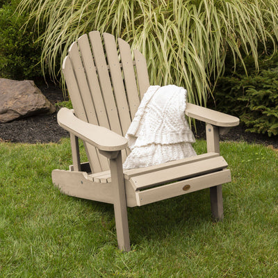 Light tan Hamilton Adirondack chair on grass with blanket