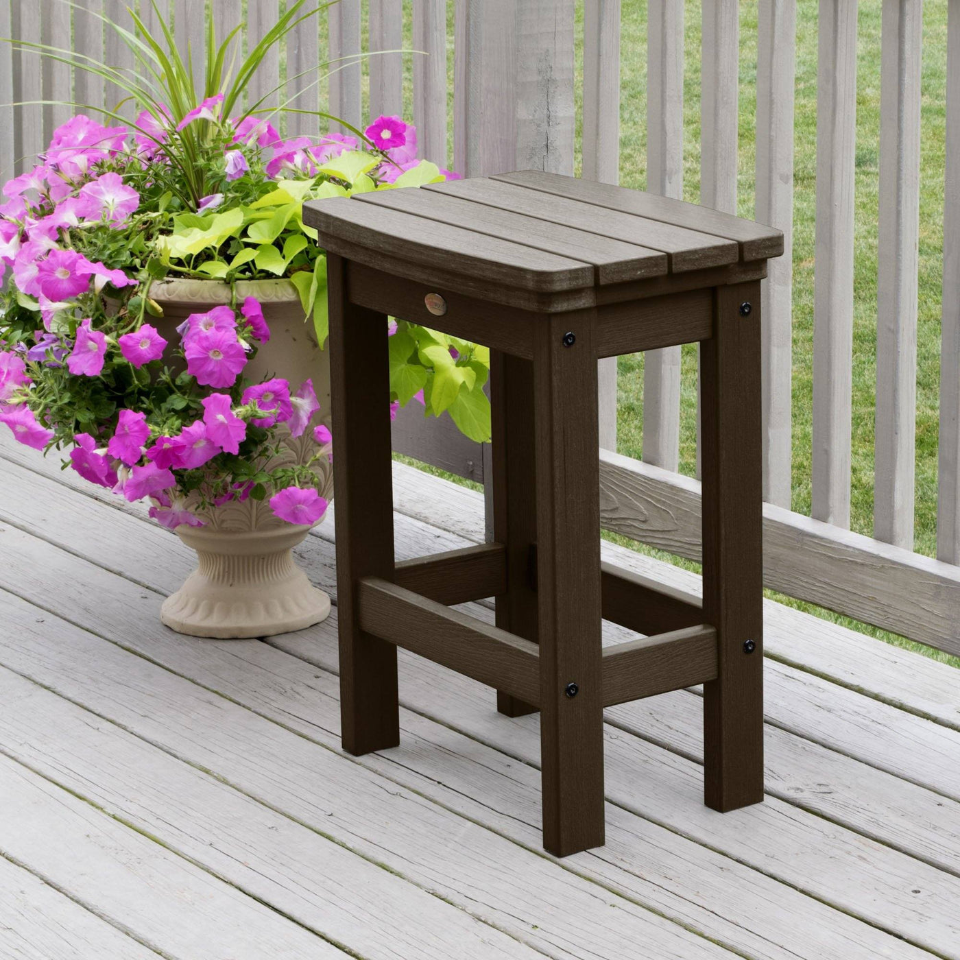 Weathered Acorn Lehigh counter height stool on deck with flowers 