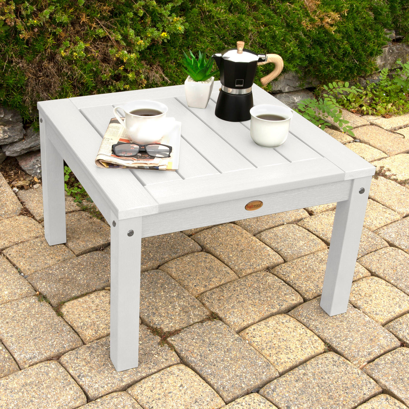 Grey table with coffee setup on stone paving